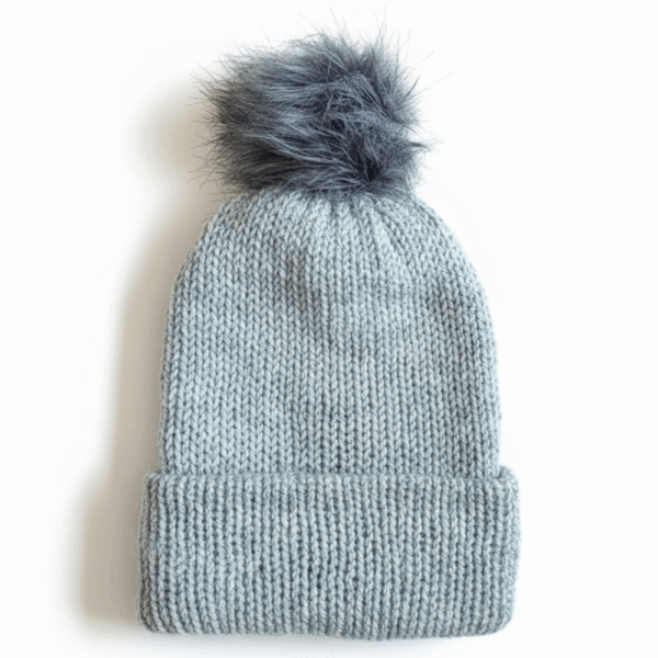 A light gray knit beanie with a dark gray faux fur pom on top, displayed on a white background