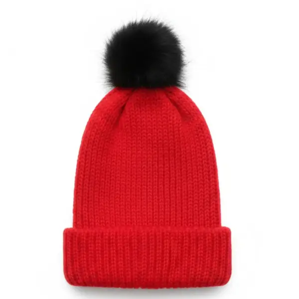 red knitted beanie with black pom pom on white background